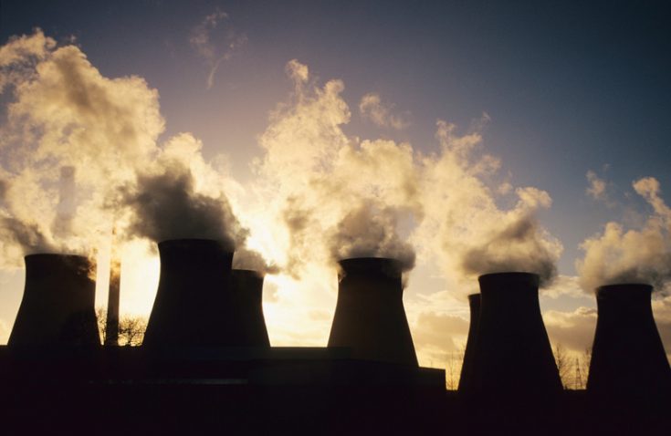 Cooling towers letting out steam and smoke at a coal-fired power station near Pontefract in Yorkshire, UK.